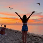 Pengunjung pantai di Miami4D, menikmati matahari terbenam yang indah dan suasana santai.